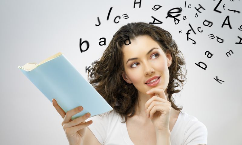 femeie care tine in mana o carte si in jurul careia zboara niste litere