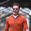 Hugh Jackman wears an orange pullover shirt and brown suede shoes in New York City