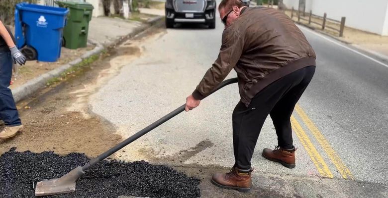 Arnold Schwarzenegger has taken it upon himself to fill two potholes