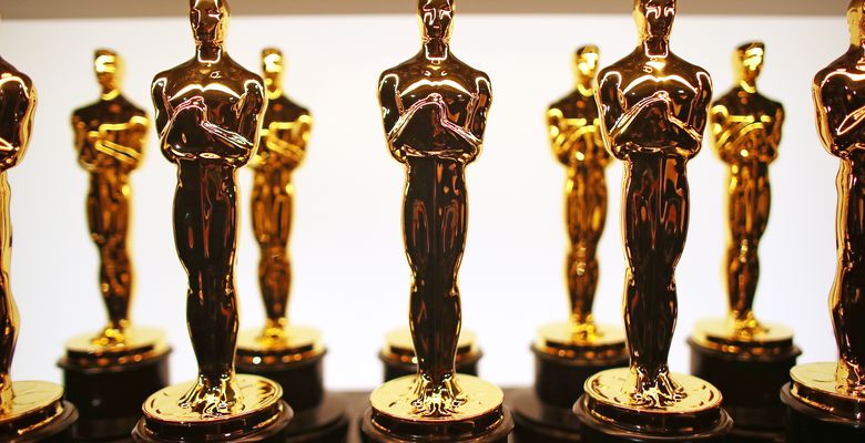 mai multe statuete oscar aranjate in ordine pe o masa