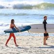 EXCLUSIVE: *NO DAILYMAIL ONLINE* Simon Baker Suffers A Cheeky Wetsuit Wardrobe-Malfunction During A Surf Session With Girlfriend Laura May Gibbs In Byron Bay
