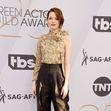 Emma Stone pozeaza pe covorul rosu de la sag awards 2019 intr-un top metalic si pantaloni la dunga