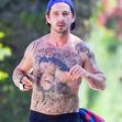 EXCLUSIVE: Shia LaBeouf still has an injured right hand as he takes a shirtless walk around his neighborhood