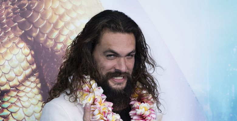 jason momoa cu ghirlanda de flori la gat face semnul rock for ever